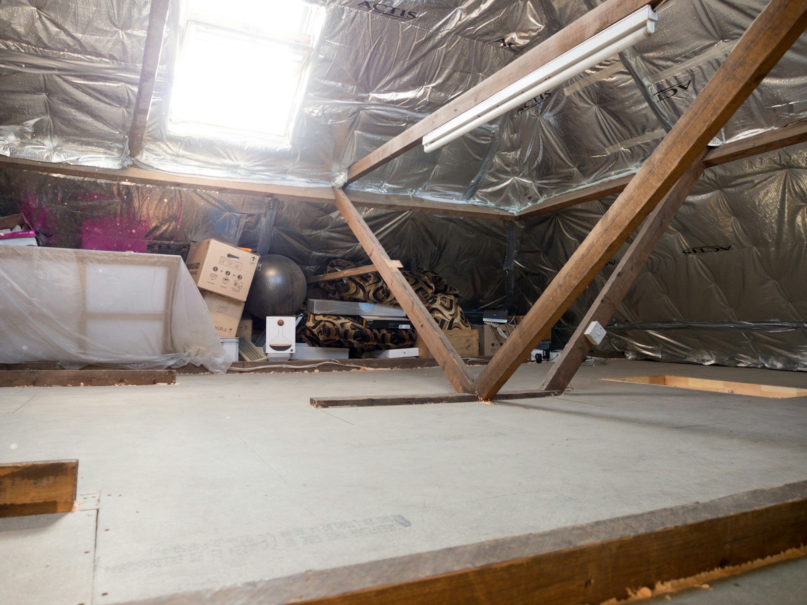 Pose de rouleaux isolants deroules sur le plancher des combles